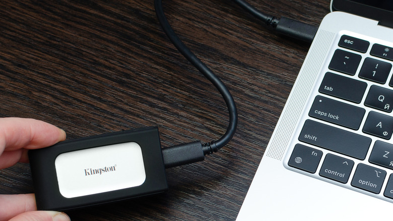 A Kingston external SSD connected to a MacBook via a high-speed USB-C cable.