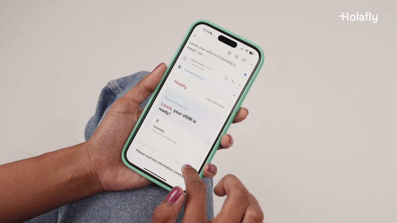 Close-up of a person activating a Holafly eSIM on their smartphone.