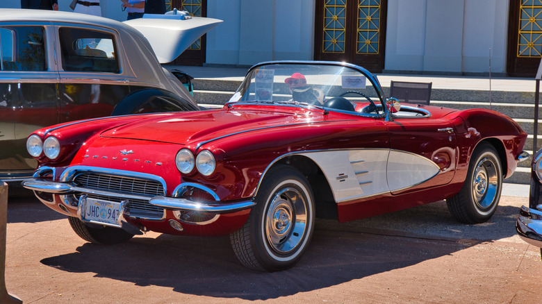 A red 1958 Chevrolet Corvette C1 convertible with white side coves.