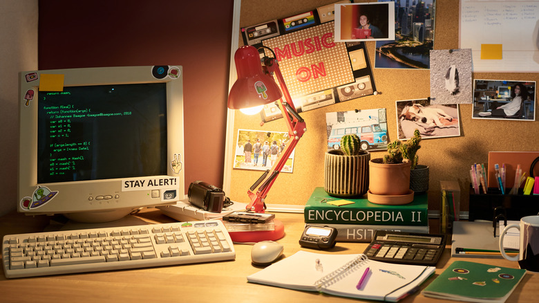 An old-school desk setup featuring vintage computer monitors, books, and classic office equipment.