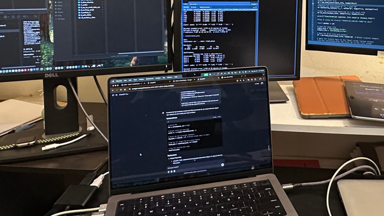A MacBook Pro connected to two external monitors showing a continuous desktop workspace.