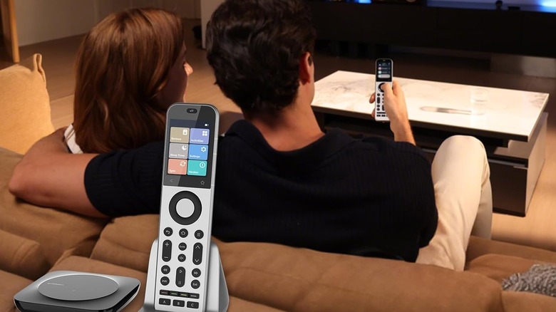 A close-up of a couple using a SofaBaton X2 universal remote to control their home theater.