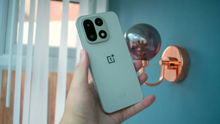 Rear view of the OnePlus 15 in the Sand Storm finish showing the textured back.