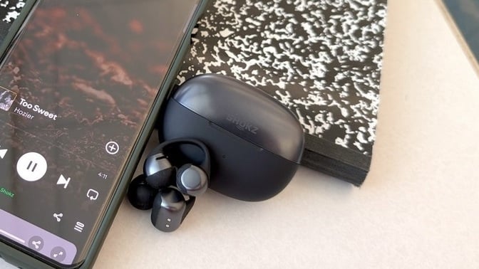 Close-up of the Shokz OpenDots One earbuds in their charging case.