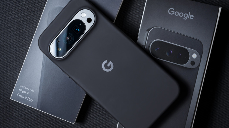A black Google Pixel 9 smartphone centered on a dark professional background.