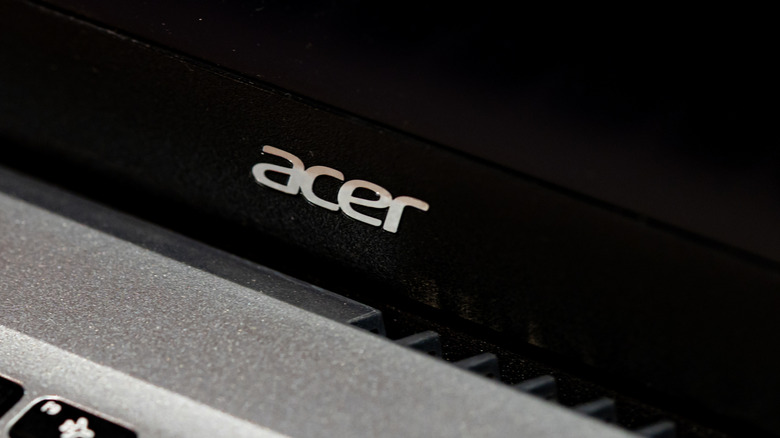 A close-up shot of the silver Acer logo on the lid of a laptop.