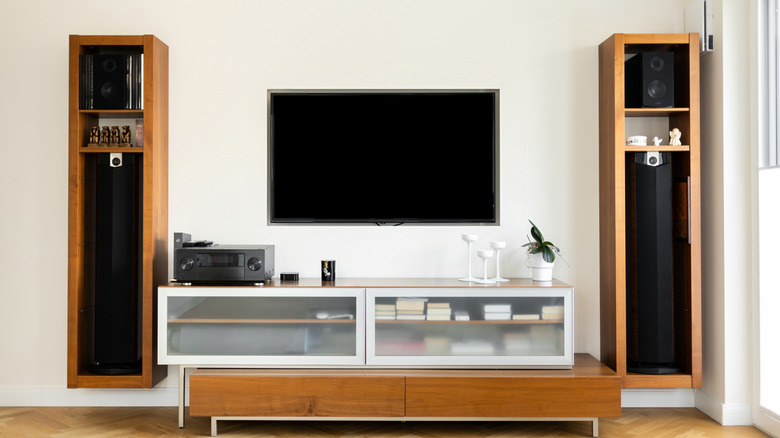 A modern home theater setup with speakers strategically placed around a living room seating area.