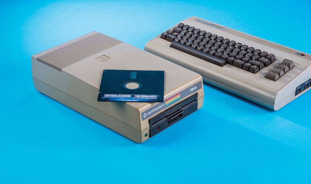 A classic Commodore 64 home computer with its accompanying floppy disk drive.
