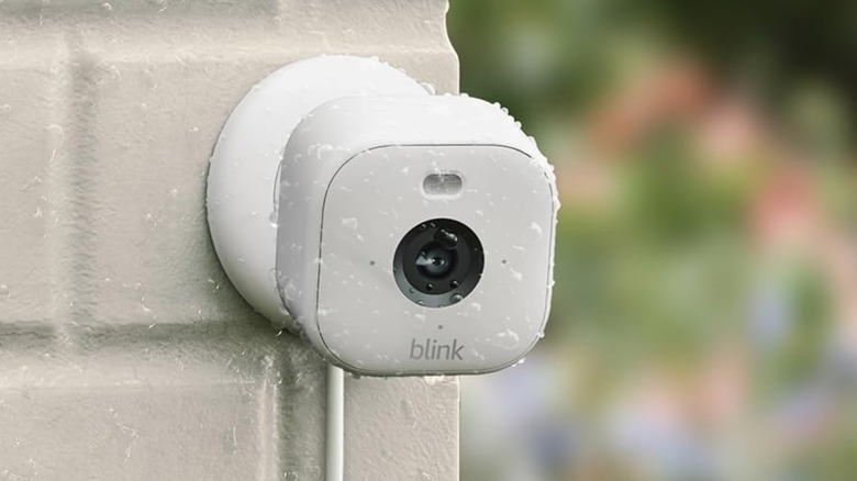Blink Mini 2 camera mounted on a white residential wall.