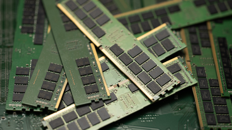 A close-up of multiple green computer RAM sticks with black memory chips.