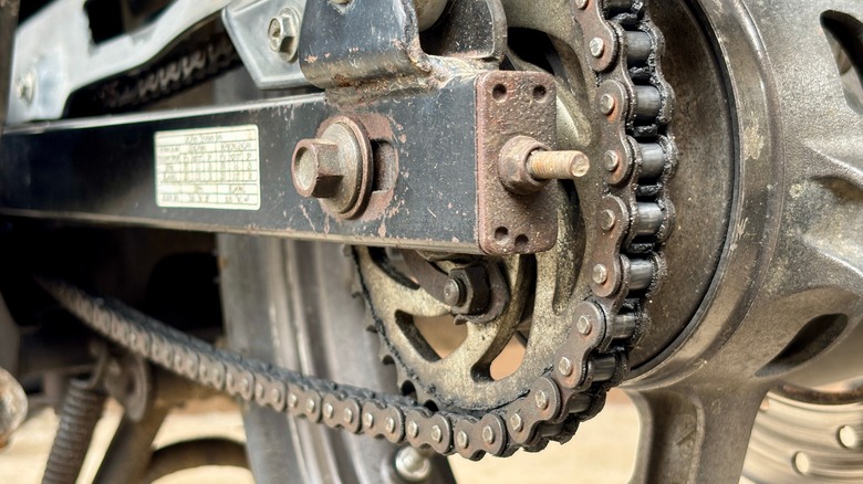An exposed motorcycle chain and rear sprocket showing the mechanical connection.