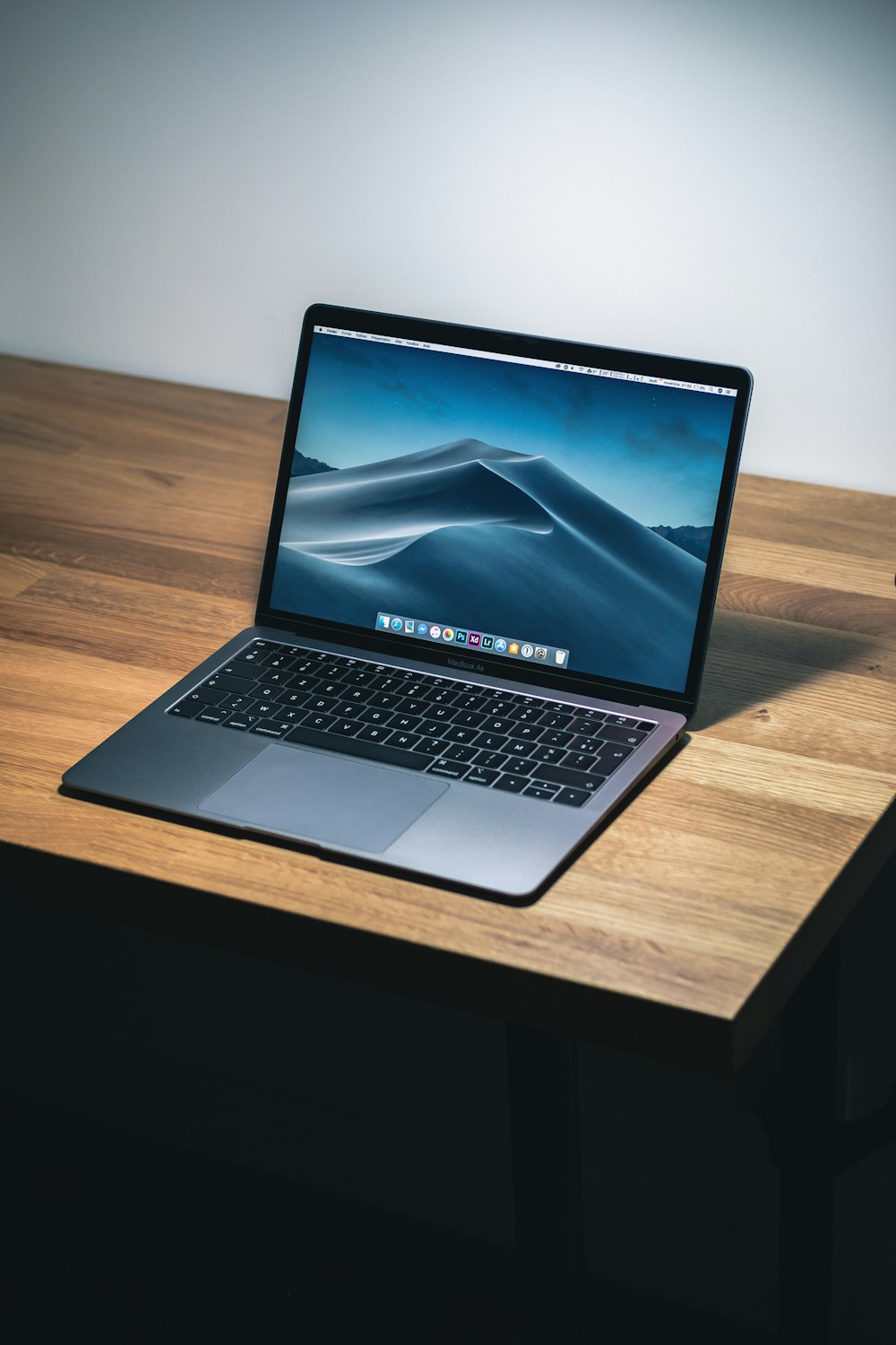 A 13-inch laptop screen showing multiple overlapping windows and the macOS Mission Control view.
