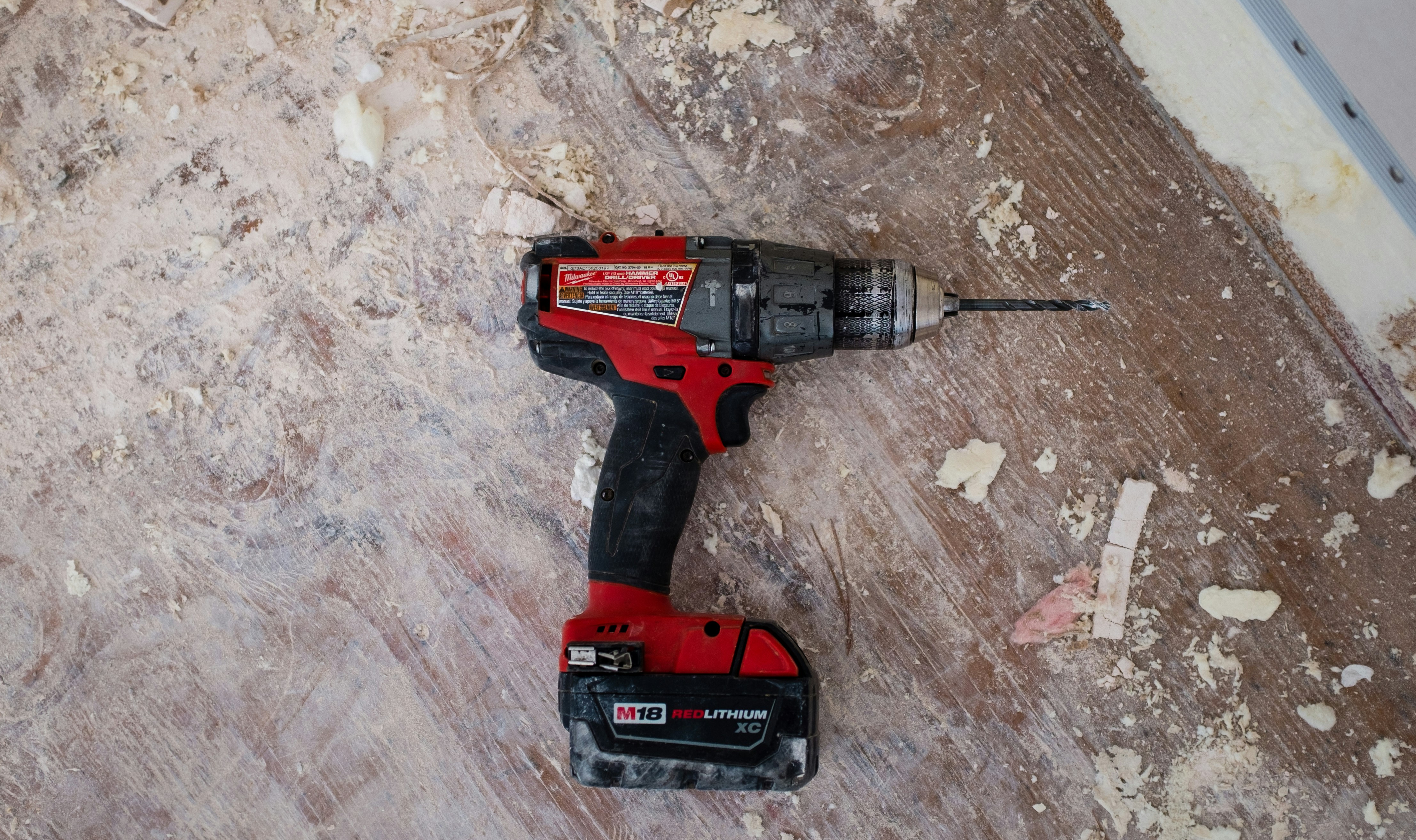 A person wearing safety gear uses a power tool in a guided workshop environment.