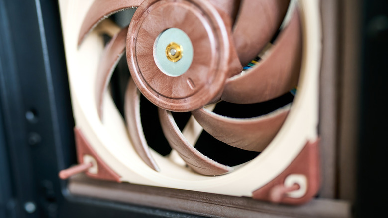 Macro shot of a computer cooling fan blades and central bearing housing.
