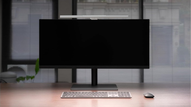 Ultrawide monitor setup with a screen-mounted light bar illuminating a tidy desk.