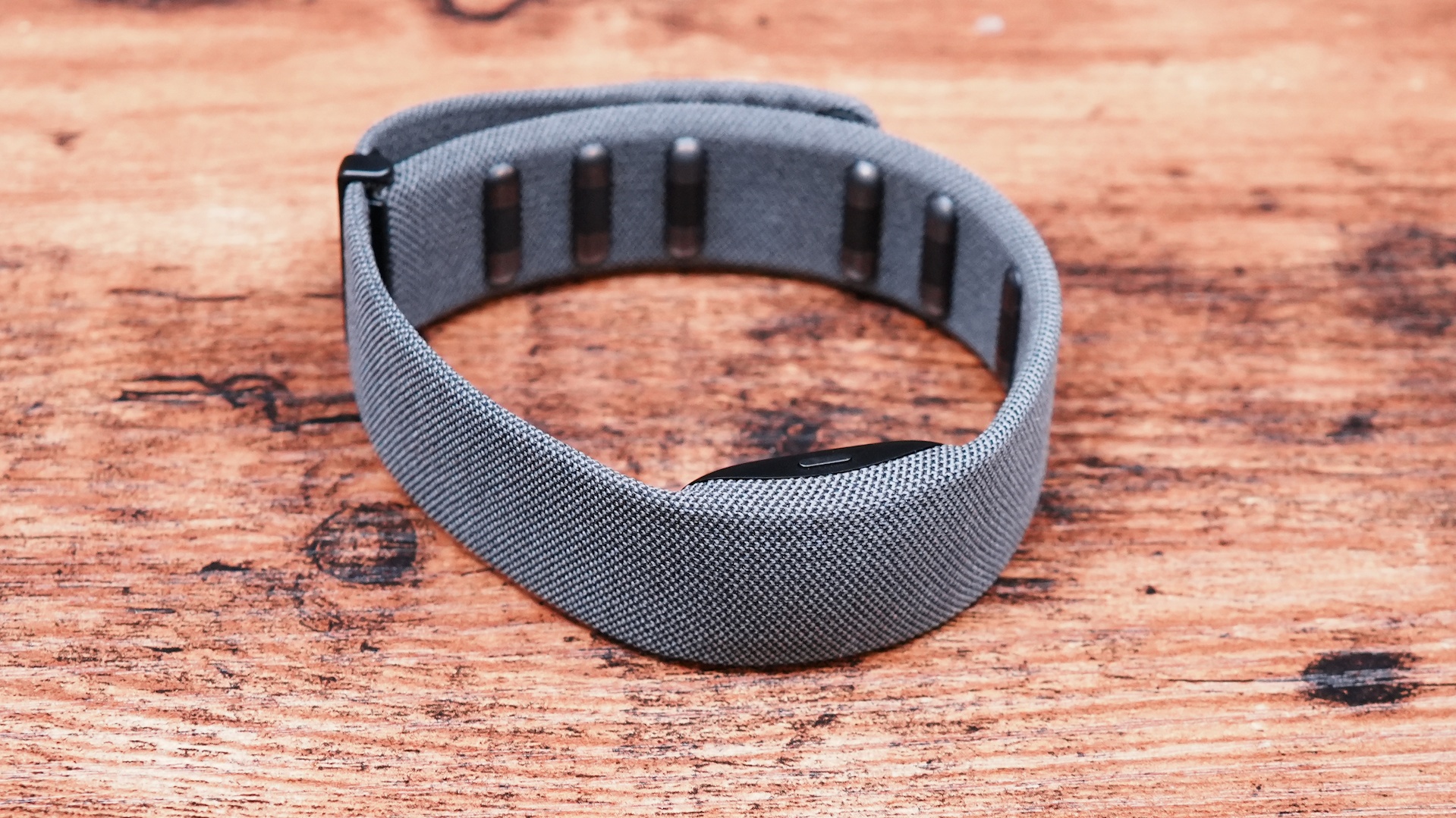 A person wearing a grey fabric wristband that functions as the Neural Band controller.