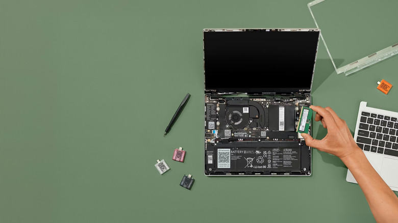 Internal components of a laptop exposed for repair on a green surface.