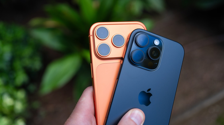 Close-up of the triple-lens camera system on the back of two flagship iPhone models.