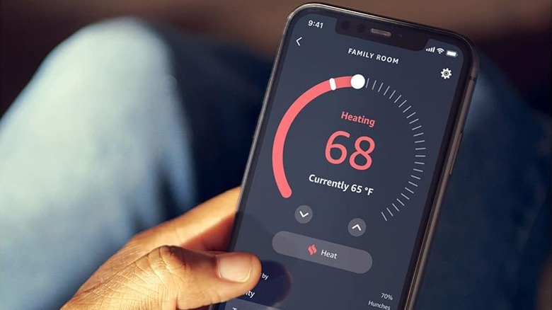 A user navigating the Alexa app on a smartphone to adjust home temperature.