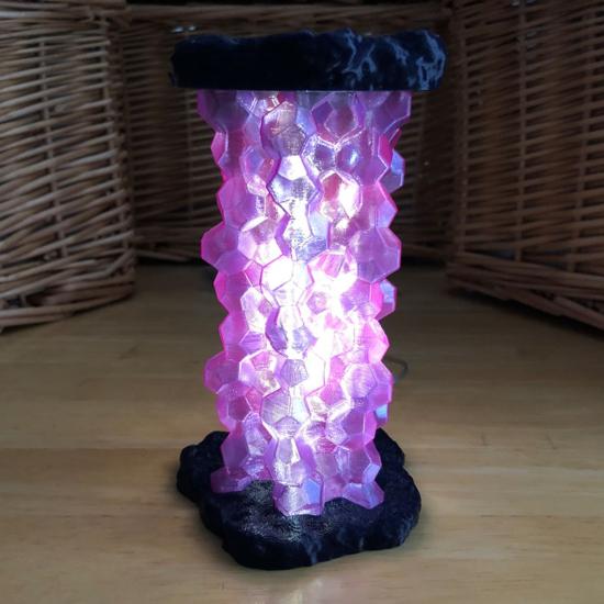 A modern 3D printed geode-style lamp emitting a warm glow for home decoration.