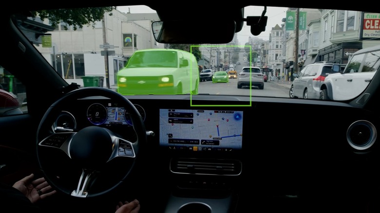 Autonomous vehicle driving through a city with Alpamayo 2 AI visual overlays