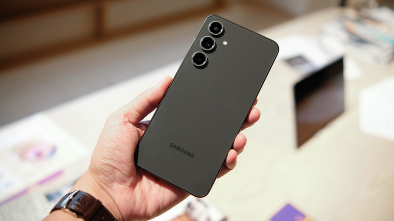 A person holding the Samsung Galaxy S24 FE during a tech event.