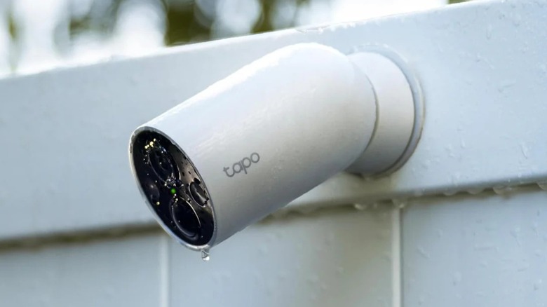 Tapo MagCam security camera mounted on a wooden residential fence.