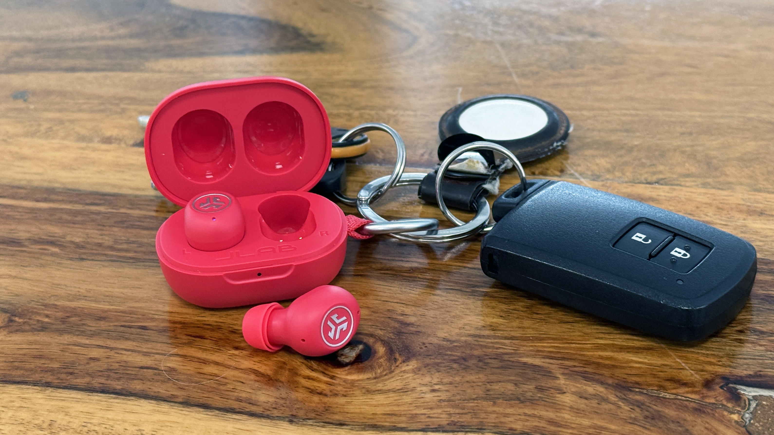 The JLab JBuds Mini case attached to a metal keychain with the lid open.