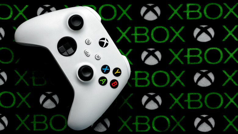 A white Xbox controller laying flat on a branded gaming mat.