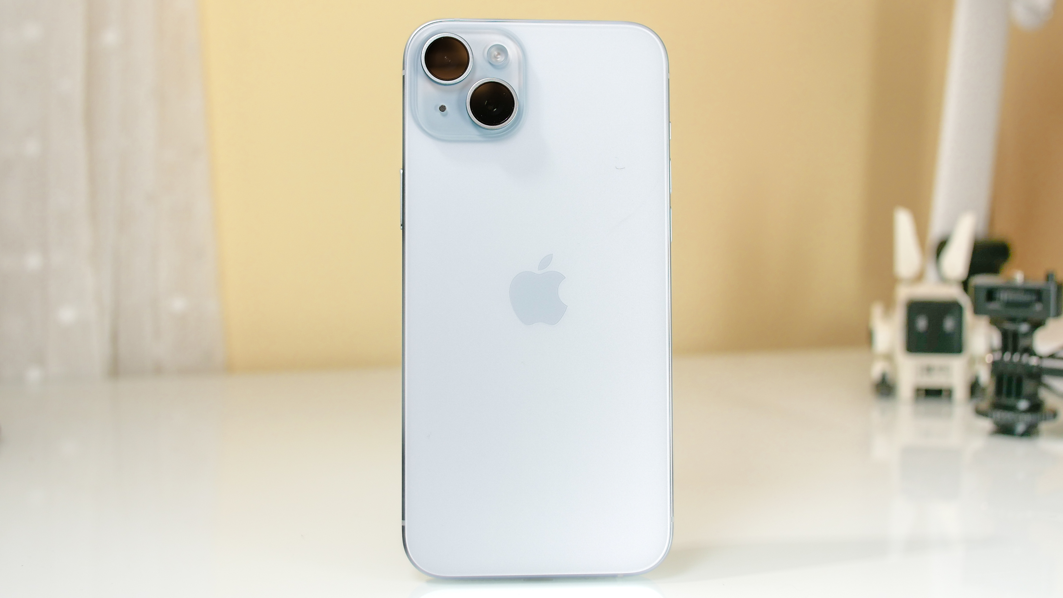 Close-up of the contoured edges and pastel color-infused back glass of the iPhone 15 Plus