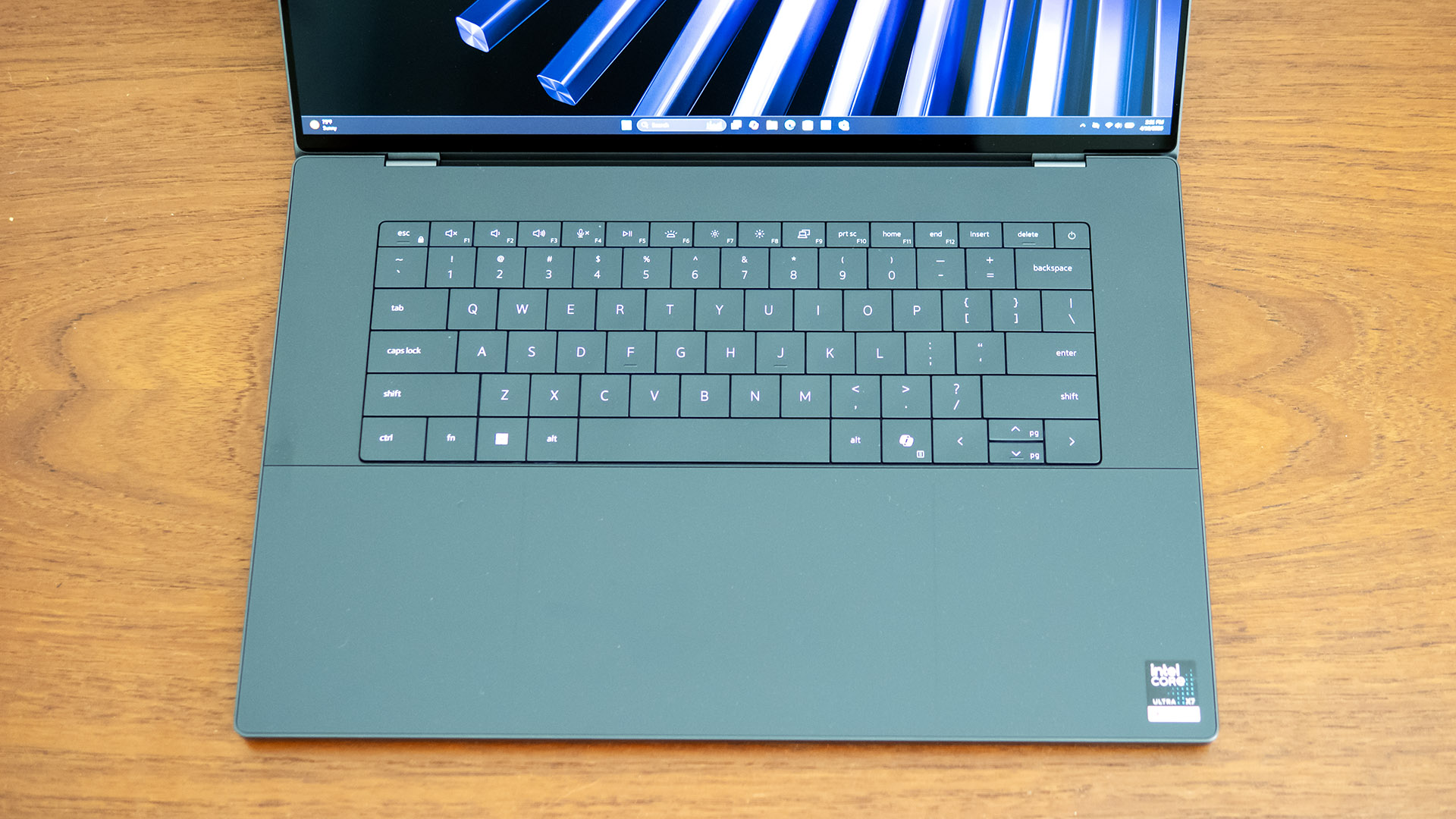 Close-up of the Dell XPS 16 keyboard and the seamless glass touchpad area.