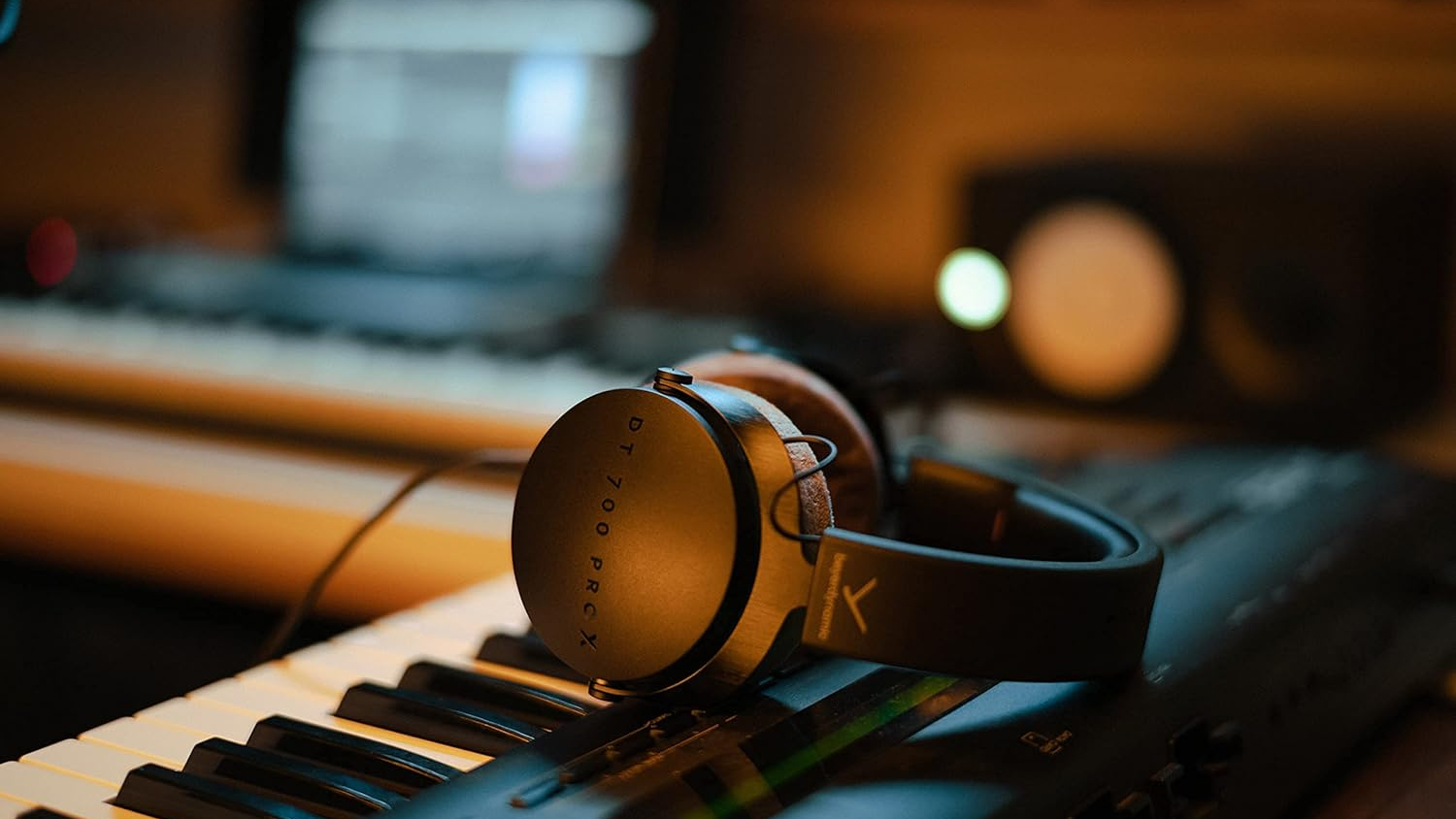 Beyerdynamic DT 700 Pro X headphones placed on a console in a music studio.