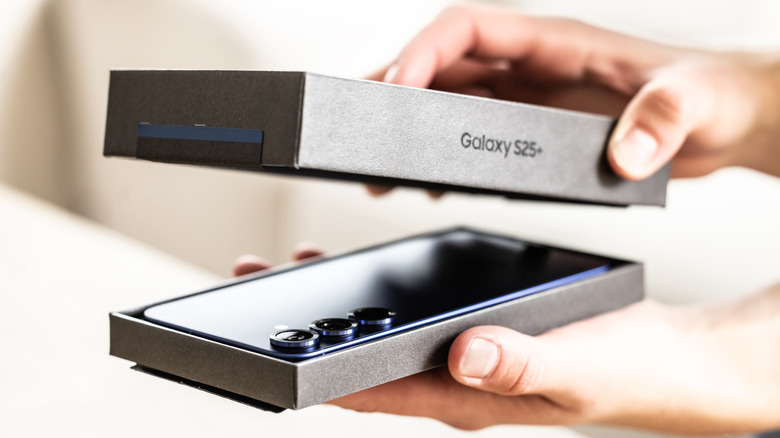 A top-down view of someone opening a Samsung Galaxy S25+ product box.