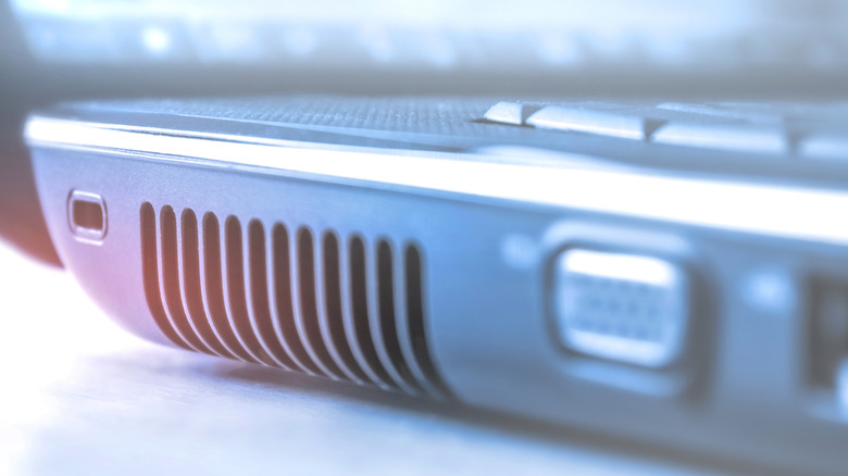 Close-up macro shot of a laptop's side exhaust vent and cooling fins.