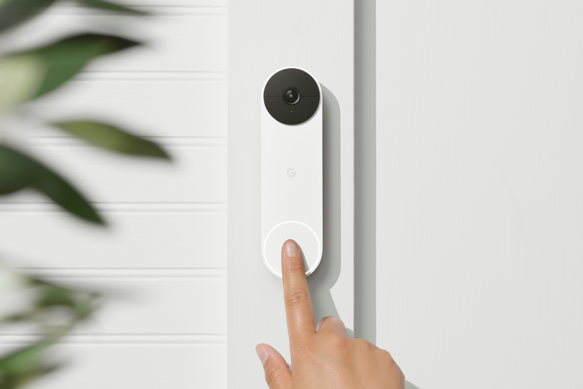 A white Nest Doorbell Battery being pressed by a finger.