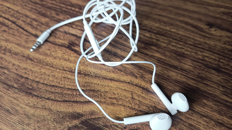 Close-up of heavily tangled white wired earphones.