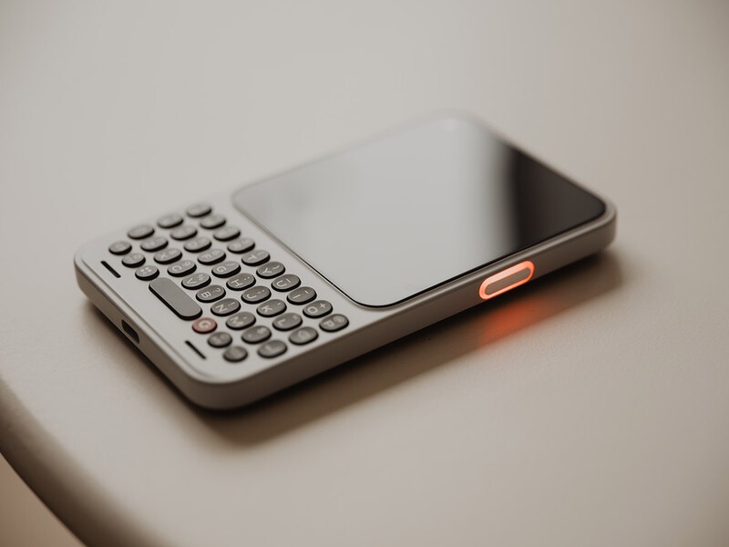 A person holding the Clicks Communicator to their ear during a voice call.