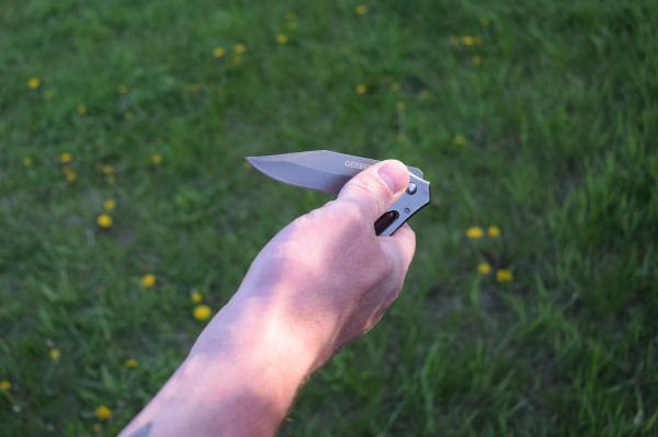 A user demonstrating the one-handed opening technique with the Gerber Paraframe.