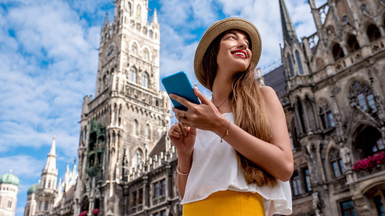 A female traveler using her smartphone for navigation while exploring an international city.