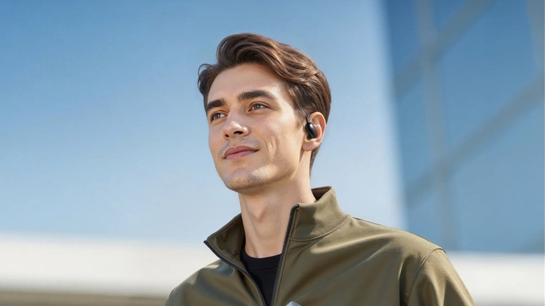 A man wearing modern Soundcore Aerofit 2 wireless earbuds integrated with AI assistant features.