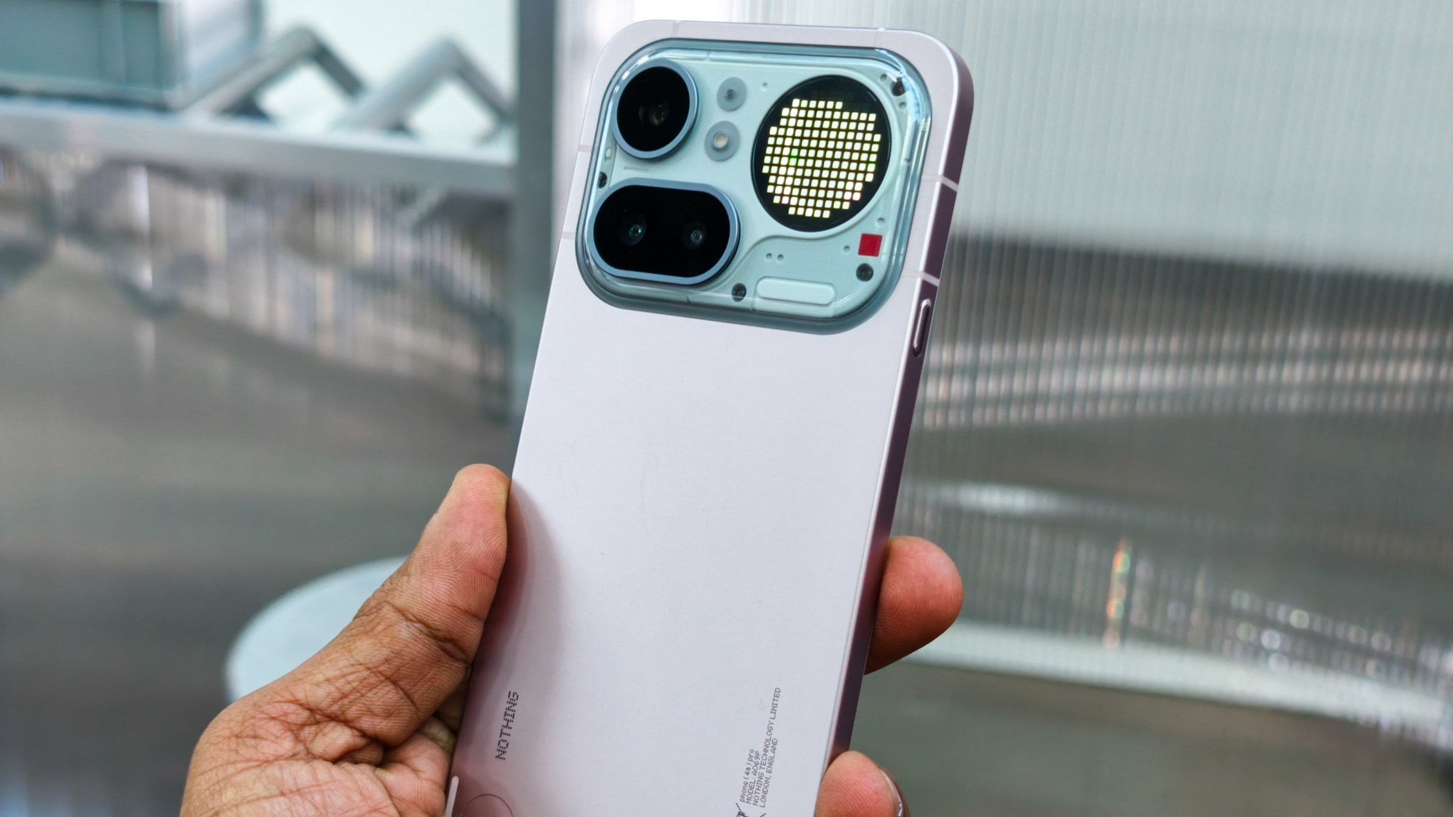 Nothing Phone 4a Pro in a pink color variant displayed at an event.