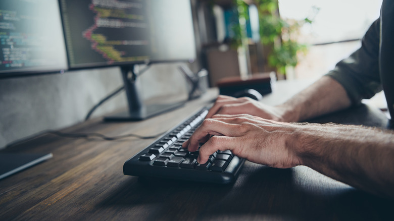 A professional setting with a person using a compact workstation including a keyboard and mouse.