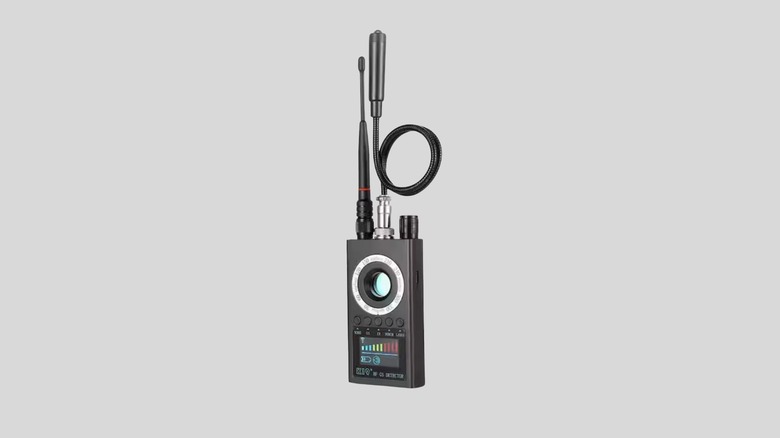 The Hom Deluxe Hidden Camera Detector being held to demonstrate its compact size and interface.