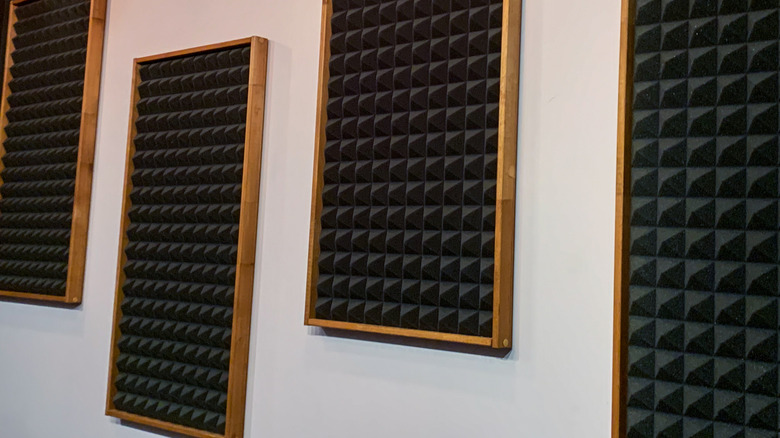 Pyramid-style wall-mounted acoustic foam panels housed in decorative wooden frames.