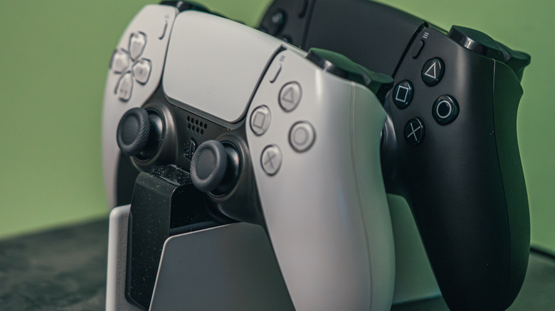 Two PlayStation 5 DualSense controllers sitting in a compact charging dock.