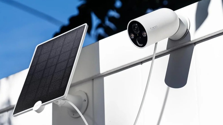 A Tapo MagCam connected to a solar panel accessory on a fence.