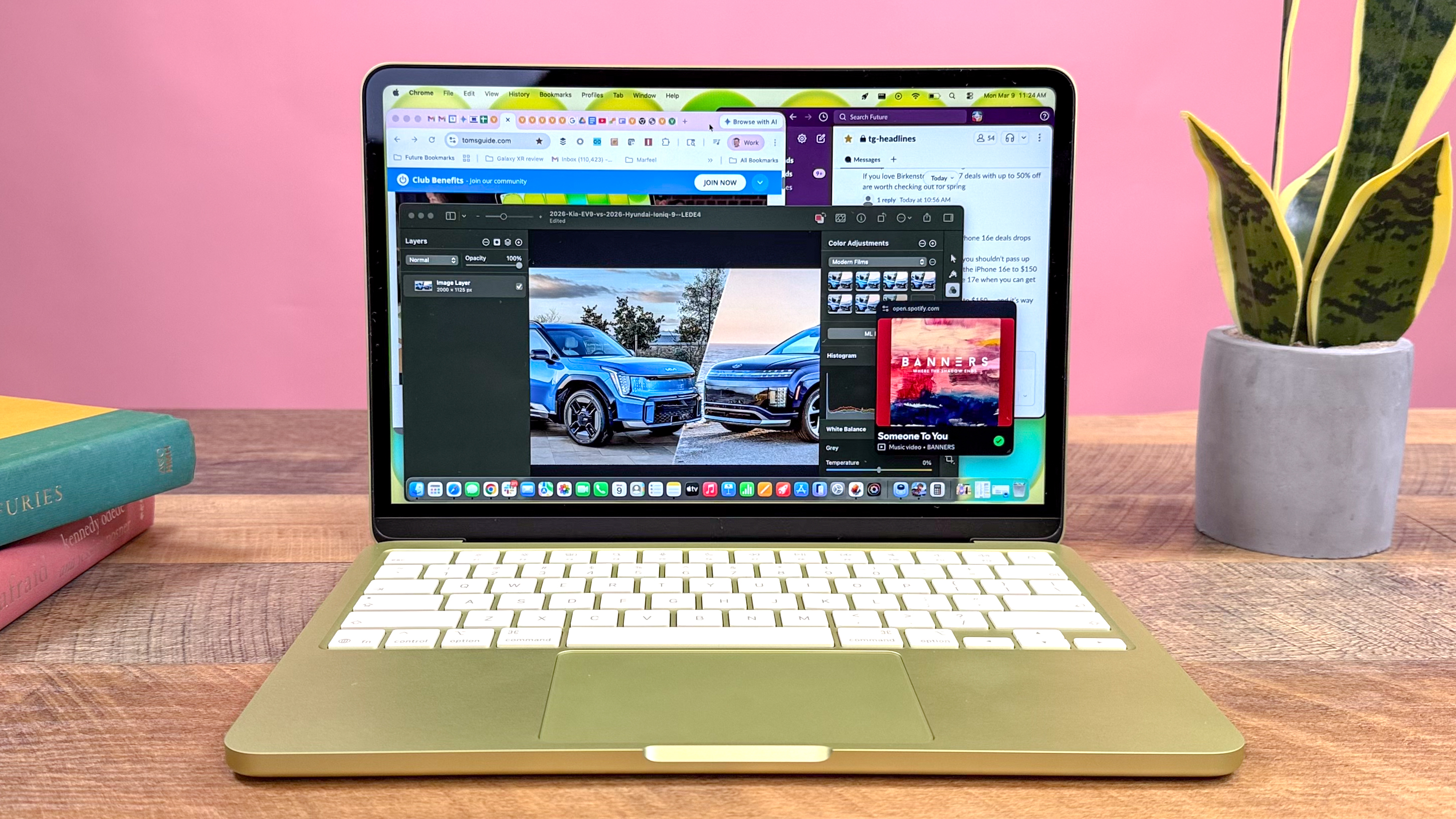 A MacBook Neo in a bright office lifestyle setting on a desk.