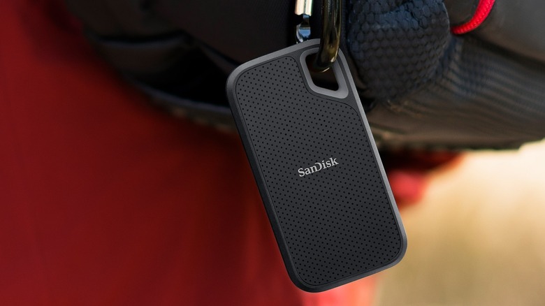 A SanDisk Extreme Go Portable SSD clipped to a carabiner, showing its small size.