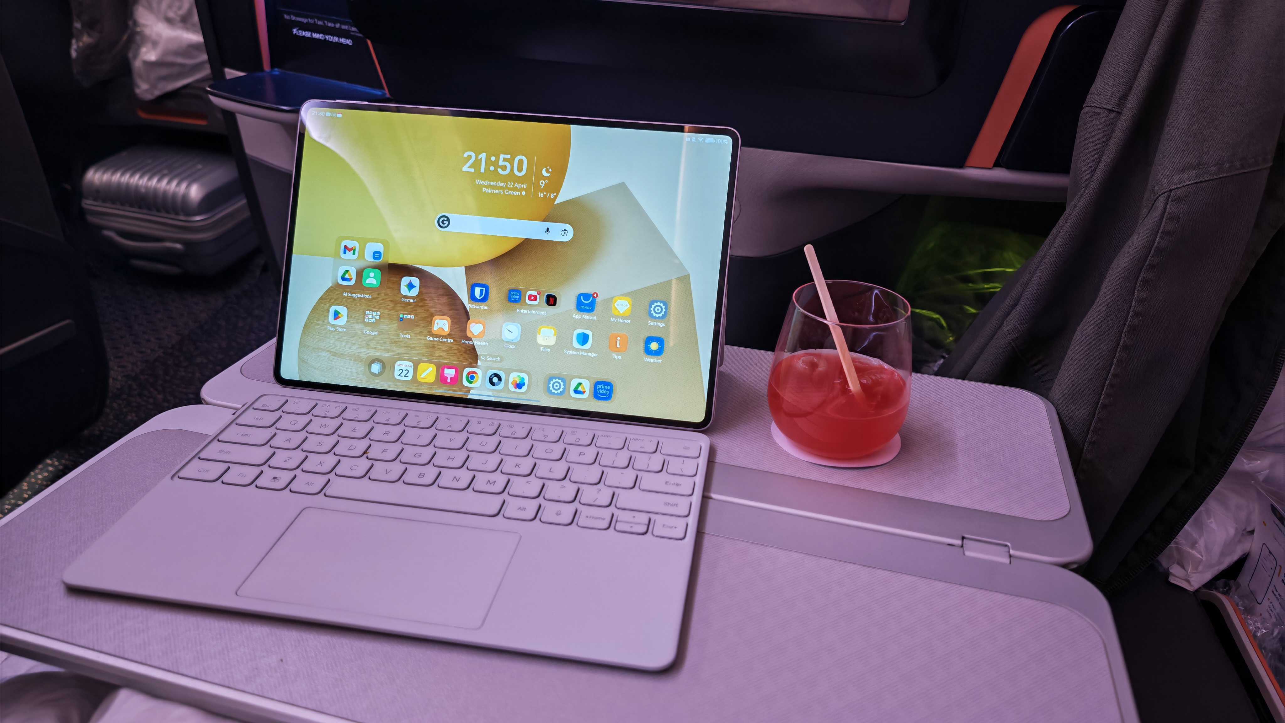 A person using an Android tablet with a keyboard during a flight.