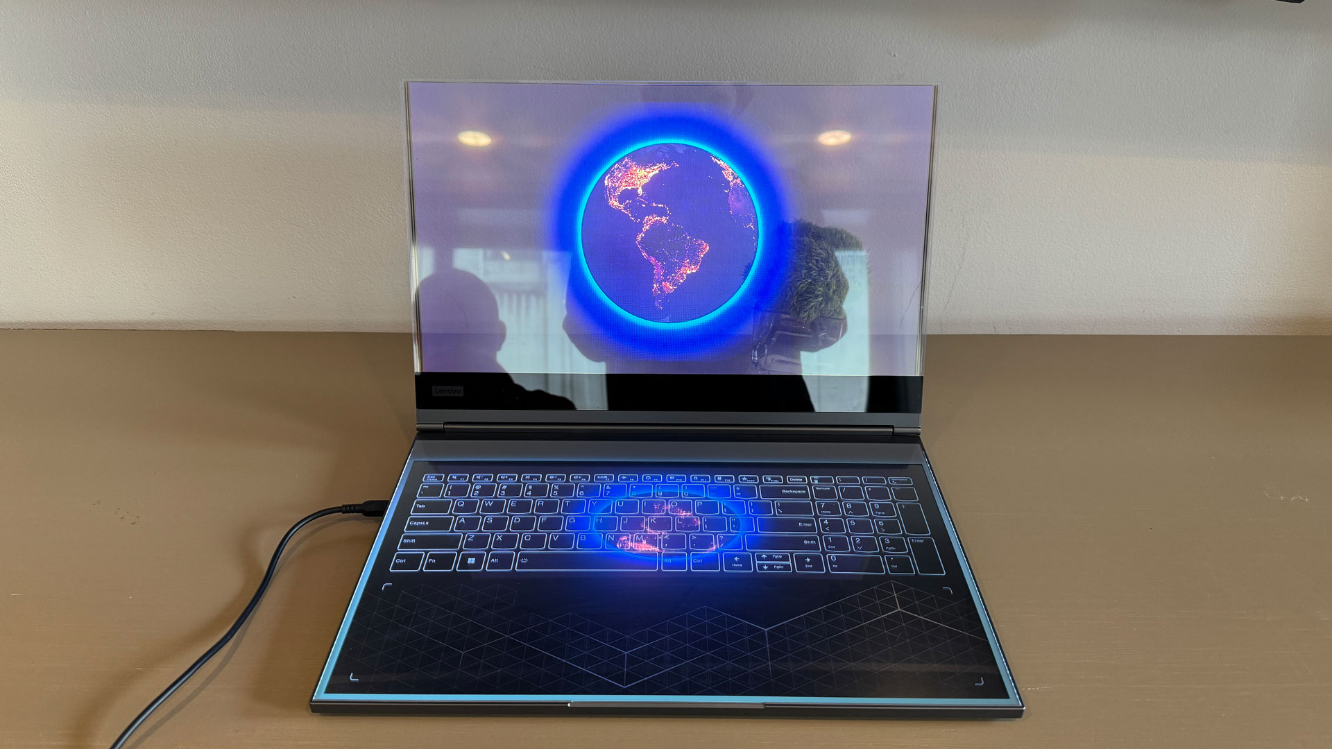 Detailed view of the haptic touch sensitive keyboard and touchpad area on the transparent laptop.